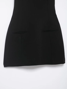 Detail of horizontal welt pockets and vertical seams on a black short sleeve dress
