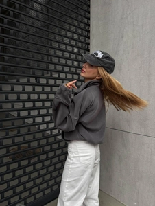 Side view of dark grey fleece sweatshirt with letter embroidery and matching baseball cap