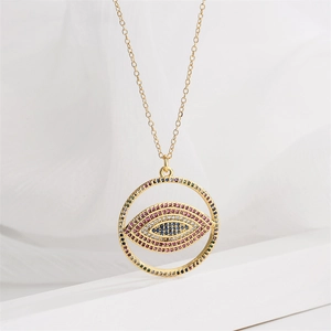 Détail d'un collier en cuivre plaqué or avec un pendentif œil maléfique en zircon coloré