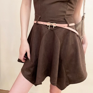 Close-up of pink bow belt on brown suede dress showing refined material texture and detail