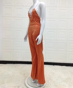 Détail de la combinaison en satin orange avec dos nu et bretelles en chaîne métallique