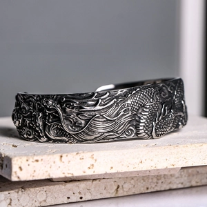 Macro detail of vintage dragon relief engraving on a silver stainless steel bracelet