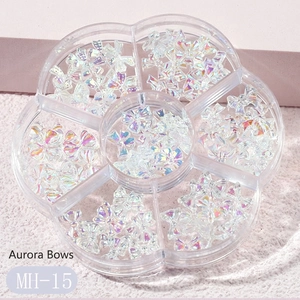 Detailed close-up of Aurora resin bow nail charms in a flower-shaped storage container