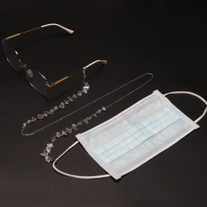 Detail of silver chain link with opal beads shown on glasses and a blue mask