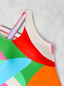 Detailed view of dual-needle stitching on vibrant patchwork swimsuit neckline and straps