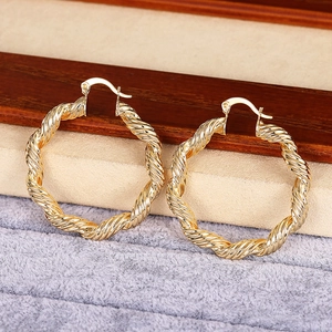 Dettaglio di orecchini a cerchio in oro 18K a spirale con trama ritorta e chiusura a scatto