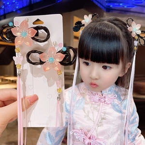 Detailed view of pink floral hair clip with fringe tassels and synthetic hair bun