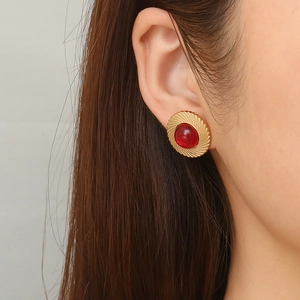 Retro round stainless steel earrings with red gems and 18K gold textured finish on model