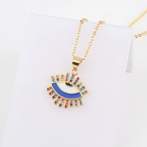 Detail of 18k gold evil eye heart pendant necklace featuring blue enamel and zircon stones