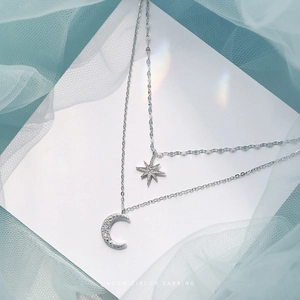 Double-layered necklace with silver moon and eight-pointed star pendants with zircons