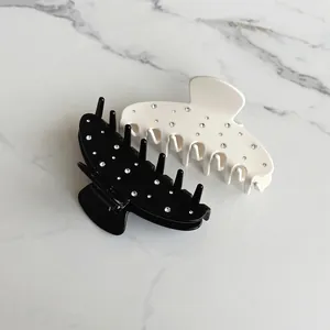 Water-drop shaped hair claws in black and cream white with sparkling rhinestones