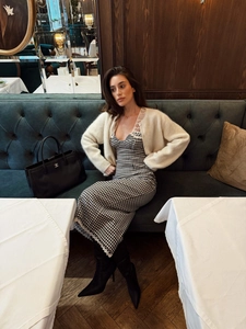 Détail de robe vintage à carreaux avec dentelle, gilet en maille et bottes montantes