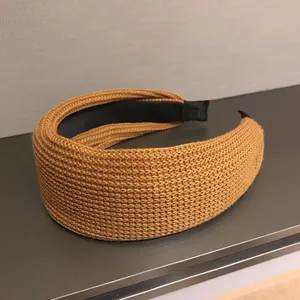 Close-up of caramel textured knit headband with a minimalist black inner lining