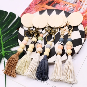 Boho beaded keychain with silicone beads, wooden disk and tassel on checkered plate