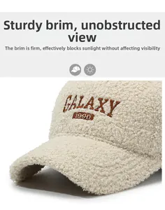 Detail of cream teddy fleece baseball cap showing brown GALAXY 1990 embroidery texture