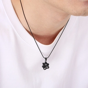 Gros plan d'un modèle portant un collier en acier noir avec pendentif patte de chien