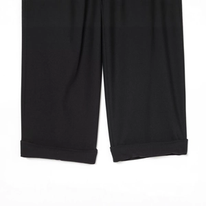 Detailed view of women's black trousers featuring stylish cuffed asymmetric hem design