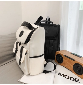 Detail of minimalist cream and black nylon backpacks with buckle closures in cozy setting