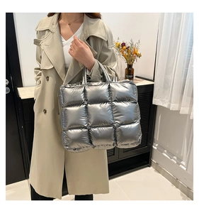 Dettaglio di una borsa tote trapuntata argento metallizzato portata da una modella