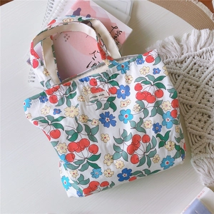 Détail du sac en toile fleurie avec imprimés cerises et étiquette en tissu simple wish