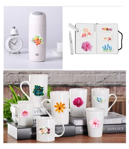 Waterproof floral stickers on a pink thermal flask, notebook, and ceramic mugs
