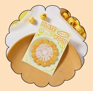 Detailed view of creative corn-shaped sticky notes on a cork plate with popcorn