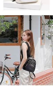 Detail of cute black mini backpack with gold pocket and cat ear accents on a model