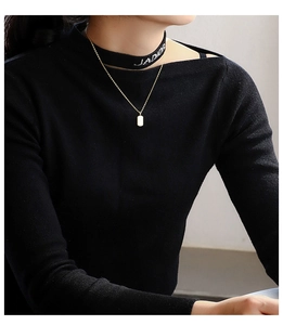 Detailed close-up of a gold-plated necklace featuring a white rectangular shell pendant