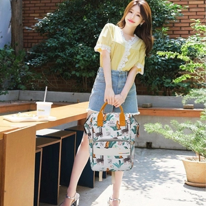 Stylish white diaper backpack with giraffe prints and yellow handles for moms