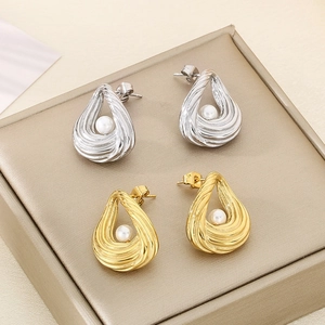 Detailed shot of striped texture teardrop earrings with pearls in gold and silver finish