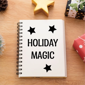 Holiday Magic spiral notebook with black stars on a festive wooden desk with decor