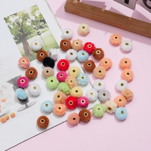 Close-up of 20mm soft faux rabbit fur pompoms with gold metal center hole beads