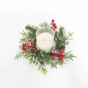 Close-up of frosted pine needles, red berries, and pine cones on a Christmas candle ring