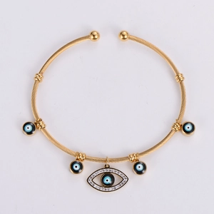 Close-up of golden evil eye cable bracelet with white zircon and enamel pendants