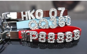Close-up of DIY leather keychains with rhinestone letters and sliding metal charms