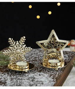 Golden Christmas snowflake and reindeer candle holders on artificial snow with bokeh background