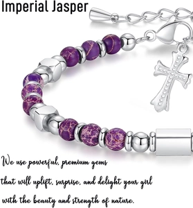 Macro detail of 4mm purple imperial jasper beads with a silver cross charm and metal accents