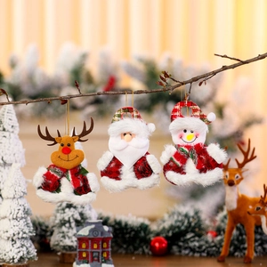 Hanging Christmas plush ornaments featuring Santa, reindeer and snowman on tree branches