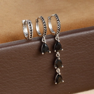 Detail of silver drop earrings set with micro-inlaid black zircon on leather box