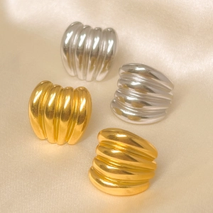 Macro shot of 18K gold and silver plated croissant rings on champagne satin fabric
