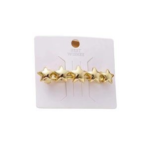 Golden five-pointed star hair clip set in shiny metal finish on a product card