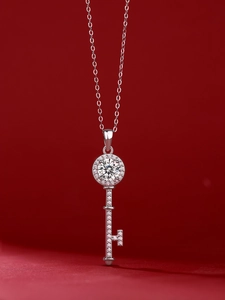 Close-up of a 925 sterling silver key pendant necklace with a brilliant round moissanite