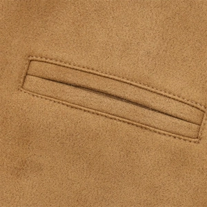 Détail de veste en daim camel montrant la poche passepoilée et les doubles coutures nettes