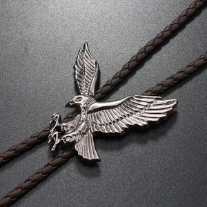 Macro detail of the silver eagle pendant and dark brown woven rope on this bolo tie