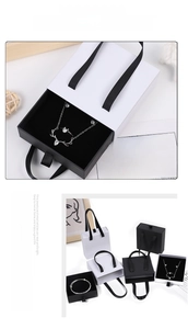 Detail of black and white drawer jewelry boxes with silk ribbon handles and elk pendant