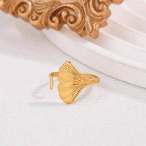 Macro detail of artistic golden ginkgo leaf ring with elegant metallic texture