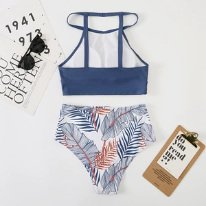 Flat lay of navy tankini top and high-waisted tropical palm leaf print bikini bottoms