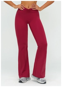 Detail of high-waisted burgundy yoga pants with V-cross ruched waistband and flared leg