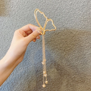 Detail of golden butterfly hair claw clip with long fringe tassels and crystal beads