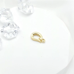 18k gold plated jewelry clasp with micro-set zircon stones on a white platform